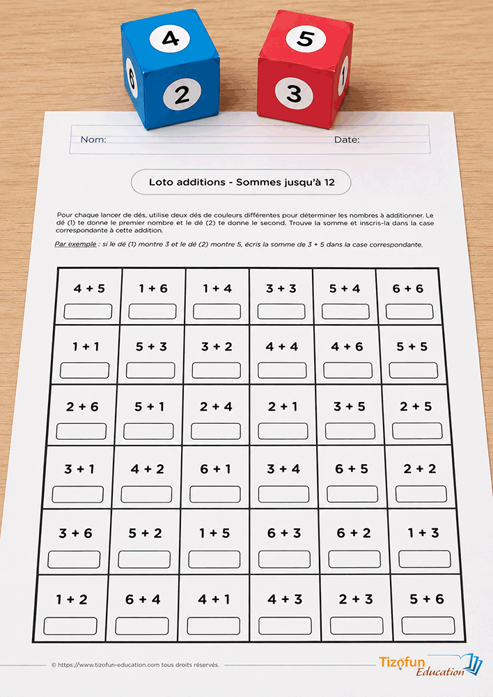 Jeu de loto additions de Tizofun Education avec une grille d'opérations imprimée et deux gros dés en papier bleu et rouge posés sur la table.